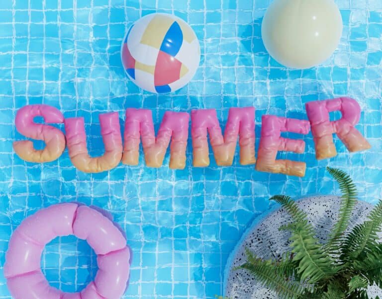 Lettres gonflables SUMMER dans une piscine avec bouée et ballon de plage, ambiance été
