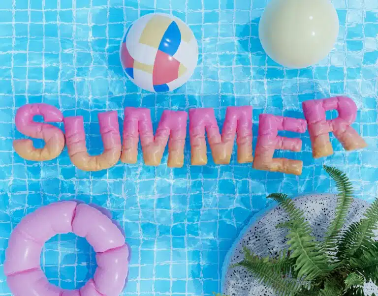 Lettres gonflables SUMMER dans une piscine avec bouée et ballon de plage, ambiance été