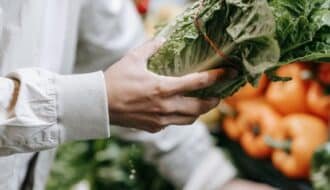 anonymous customer picking greens in supermarket