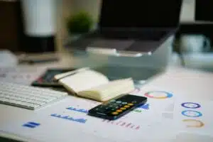 bureau avec graphiques financiers, calculatrice et carnet pour préparer son budget mensuel