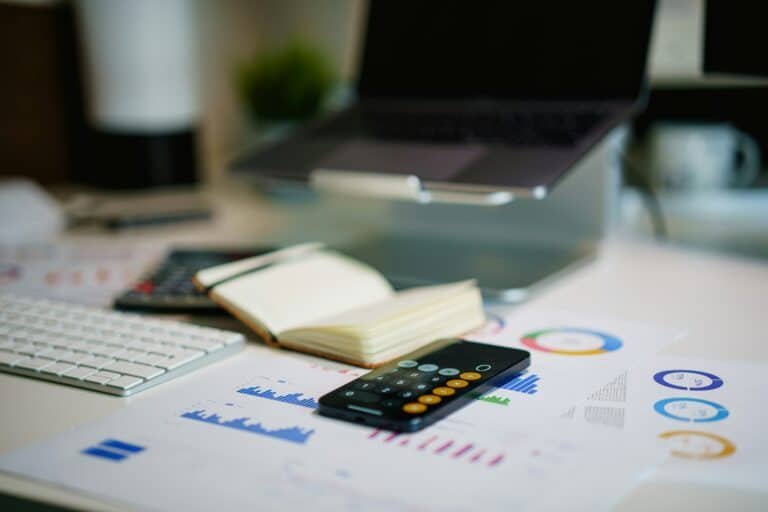 bureau avec graphiques financiers, calculatrice et carnet pour préparer son budget mensuel