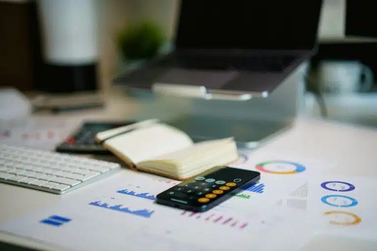 bureau avec graphiques financiers, calculatrice et carnet pour préparer son budget mensuel