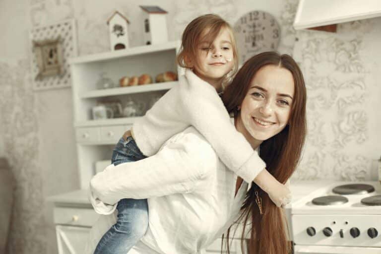woman giving daughter piggyback ride