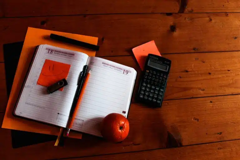 Photo représentant un agenda et une calculatrice illustrant les dépenses de rentrée à ne pas oublier